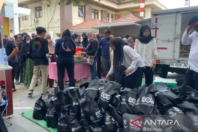 Warga mengantre di pasar murah untuk membeli paket sembako bersubsidi