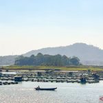 Pemandangan waduk yang luas dengan perbukitan di kejauhan