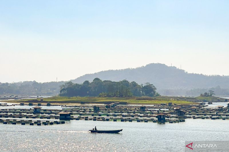 Pemandangan waduk yang luas dengan perbukitan di kejauhan