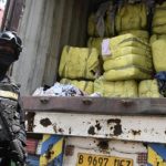 Petugas memeriksa tumpukan bal pakaian bekas hasil penindakan impor ilegal