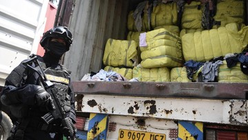 Petugas memeriksa tumpukan bal pakaian bekas hasil penindakan impor ilegal