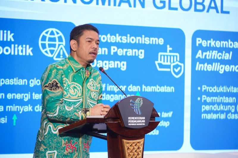 Pejabat Kementerian Perdagangan berpidato di mimbar dengan latar panel perekonomian global