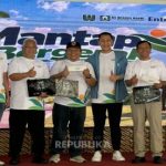 Sejumlah peserta program Mantap Bergerak berfoto bersama sambil memegang plakat di depan latar acara