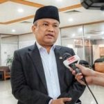 Anggota DPR RI berbicara kepada wartawan dalam sebuah wawancara di dalam ruangan