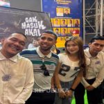 Sekelompok orang berpose bersama di depan poster film Gak Masuk Akal dari Leo Pictures