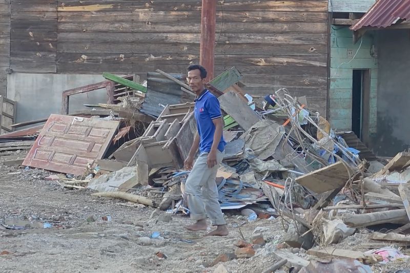 Warga membersihkan rumah dari lumpur setelah banjir surut di Desa Badak, Gayo Lues