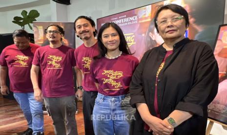 Para pemain dan sineas film Yang Datang dan Yang Pergi berpose di konferensi pers dengan kaus marun bertuliskan judul film