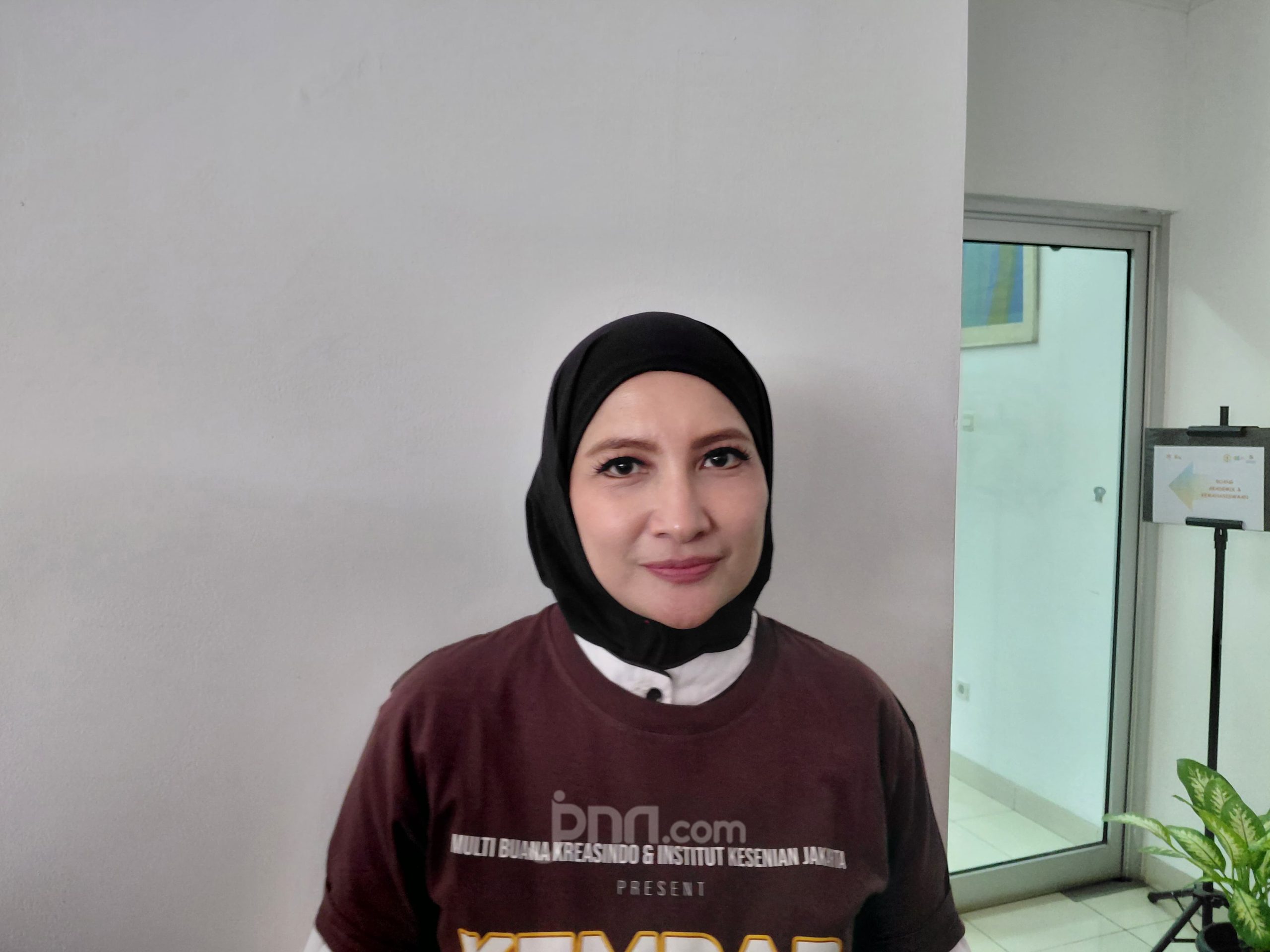 Aktris Natalie Sarah berhijab hitam dan berkaus marun berpose di dalam ruangan