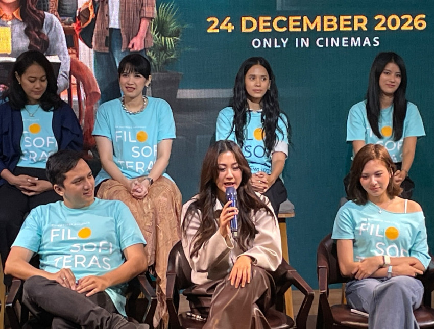 Sherina Munaf berbicara dengan mikrofon di depan para pemain film Filosofi Teras yang memakai kaus film