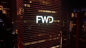 Logo FWD pada gedung bertingkat di malam hari