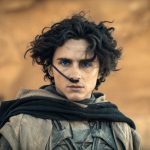 Tokoh Paul Atreides di tengah lanskap gurun planet Arrakis dalam film Dune