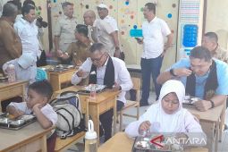 Sejumlah siswa menyantap makanan bergizi gratis yang dibagikan di sekolah