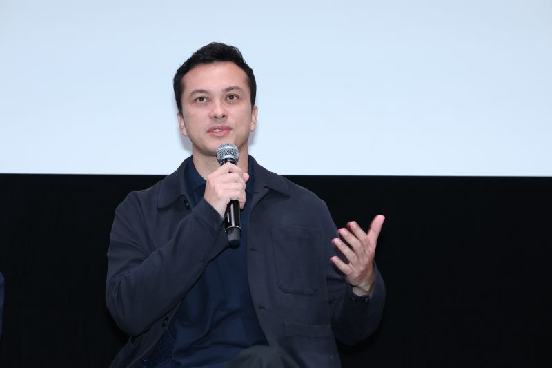 Nicholas Saputra berbicara sambil memegang mikrofon dalam sesi diskusi film