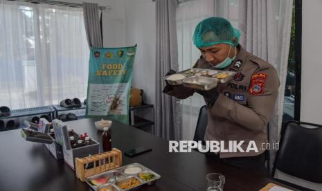 Petugas dapur program makan bergizi sedang menyiapkan makanan dalam jumlah besar