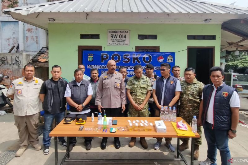 Petugas kepolisian saat operasi pemberantasan narkoba di kawasan permukiman