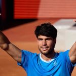 Carlos Alcaraz memegang raket tenis di lapangan
