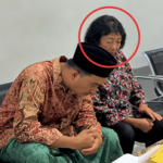 Seorang perempuan dan laki-laki berpeci duduk berdampingan di ruang tunggu Polres Pamekasan selama proses pemeriksaan