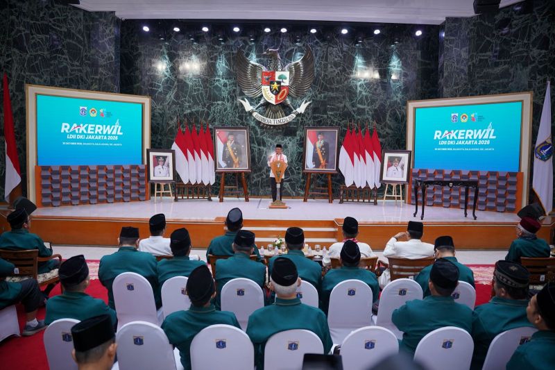 Seorang pembicara berdiri di panggung rapat kerja wilayah LDII di hadapan peserta yang duduk di aula