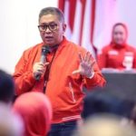 Sekjen PDI Perjuangan Hasto Kristiyanto berjaket merah berbicara dengan mikrofon di hadapan peserta konsolidasi
