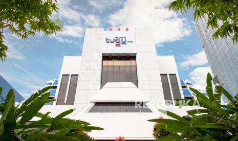 Gedung kantor Tugu Insurance dengan logo Tugu di bagian atas, dikelilingi pepohonan