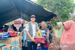 Petugas menyerahkan paket bantuan kepada warga di posko pengungsian banjir