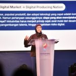 Menteri Komunikasi dan Digital Meutya Hafid berpidato di podium dengan latar slide bertuliskan Dari Digital Market menuju Digital Producing Nation