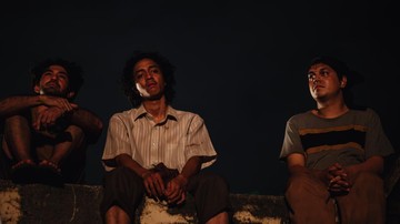 Tiga pemuda dalam adegan malam film Laut Bercerita yang mengisahkan kelompok aktivis mahasiswa Winatra