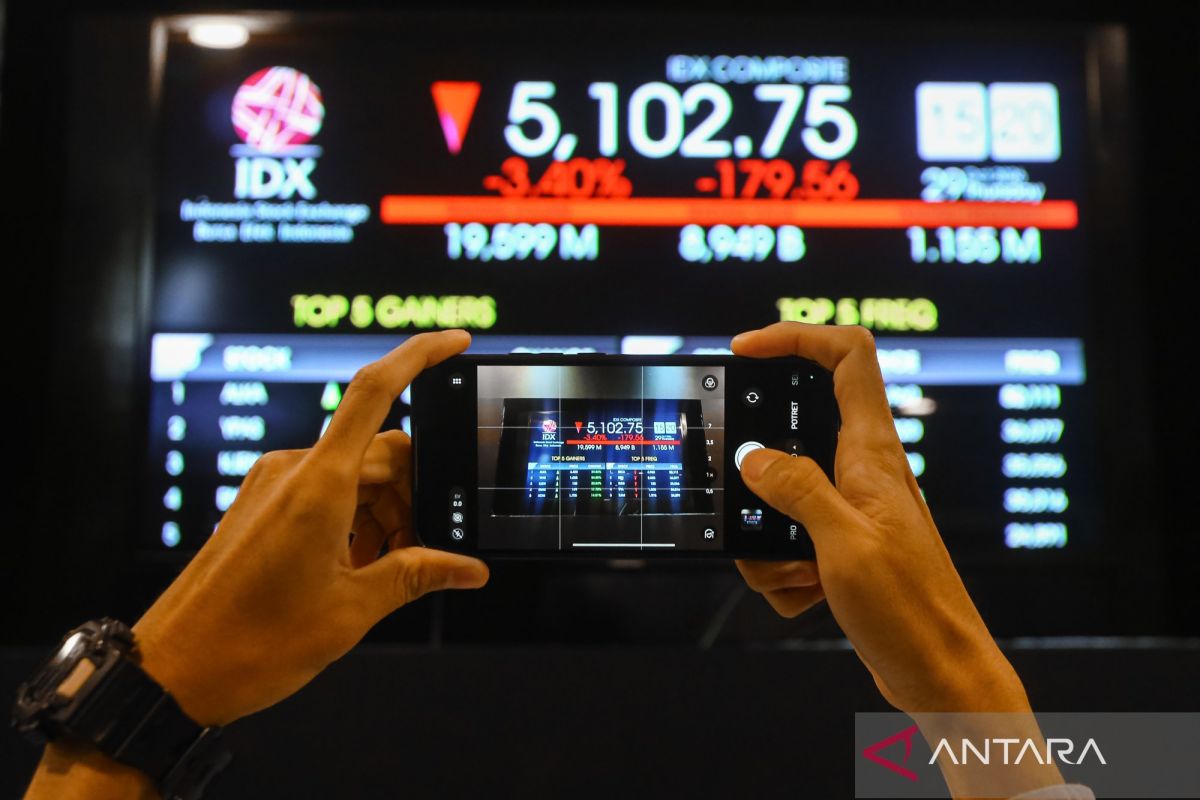 Pengunjung memotret layar pergerakan IHSG di Bursa Efek Indonesia, Jakarta