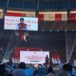 Suasana peringatan satu tahun Sekolah Rakyat di gedung olahraga di Makassar, dengan spanduk acara di atas panggung dan hadirin di kursi penonton