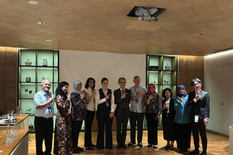 Sekelompok orang berpose bersama dalam sebuah acara di dalam ruangan