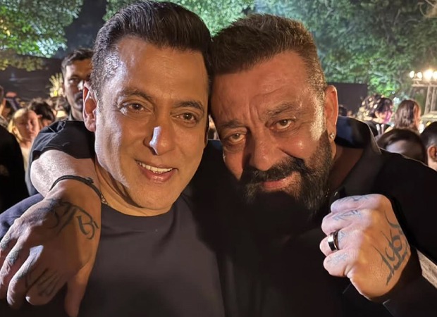 Salman Khan dan Sanjay Dutt berpose berdampingan sambil tersenyum pada sebuah acara malam hari