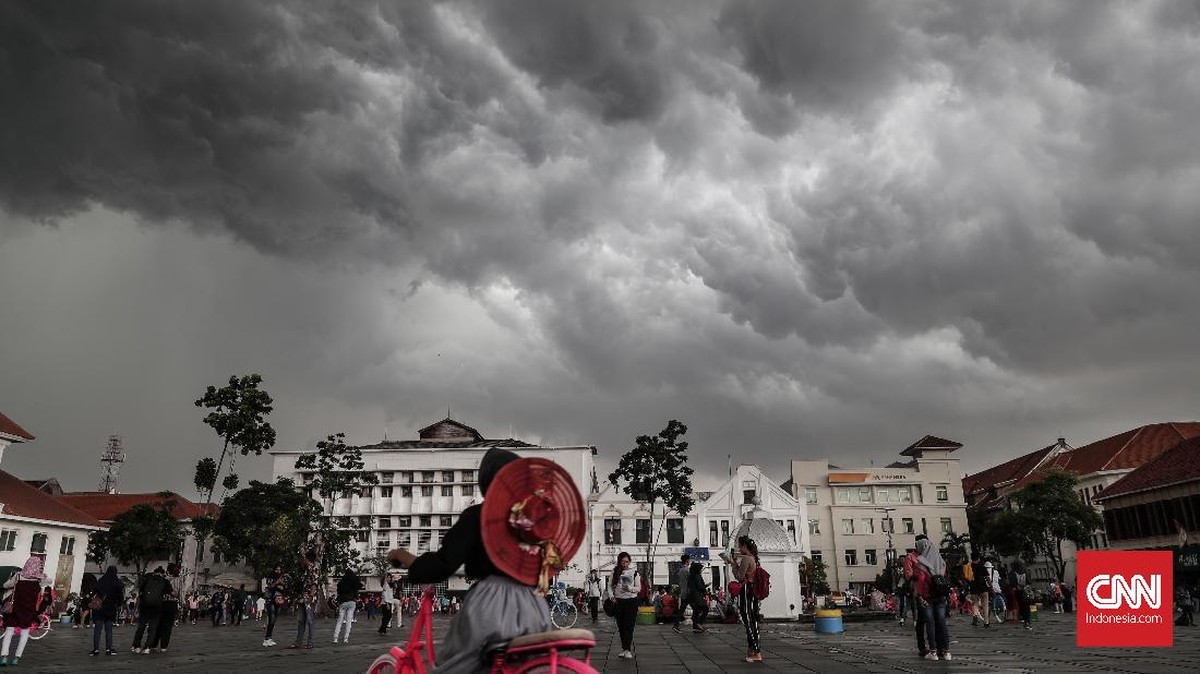 Awan gelap tebal menggantung di atas kawasan perkotaan sebelum hujan lebat