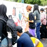 Sejumlah perempuan melukis bersama pada dinding putih dalam aksi simpatik peduli kebakaran hutan dan lahan