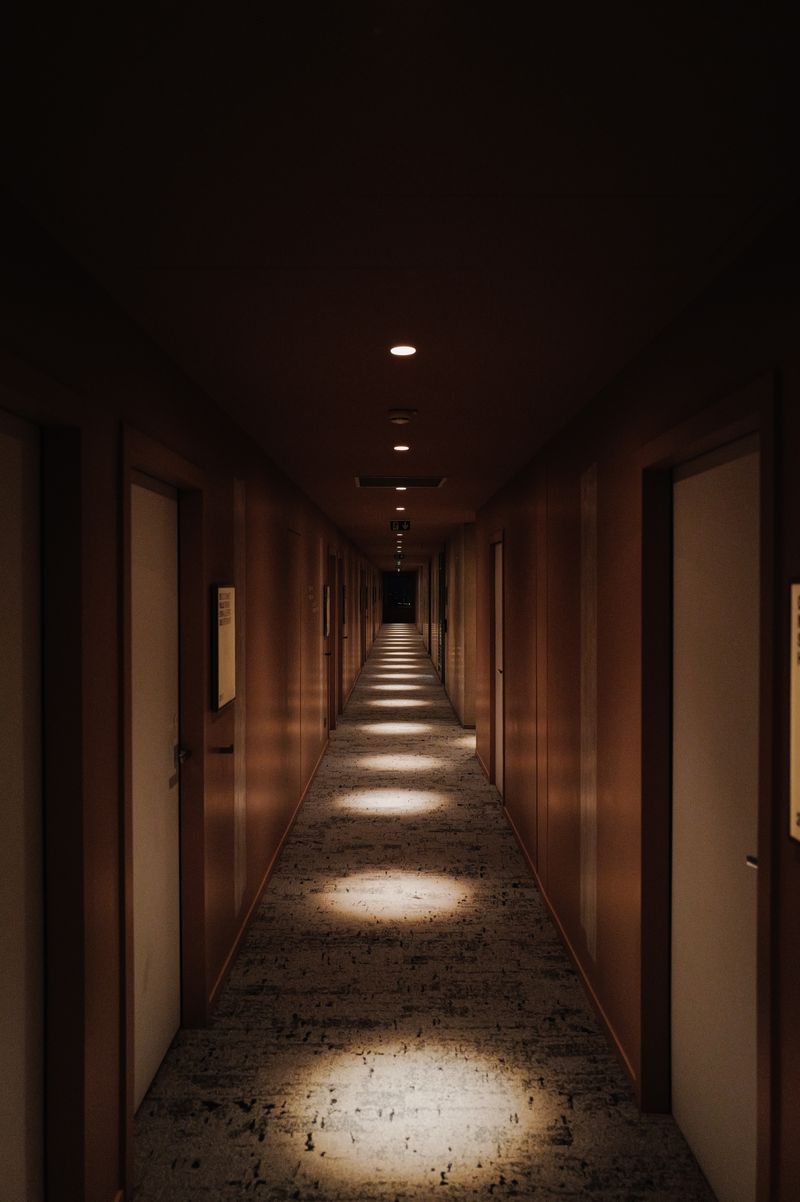 Lorong motel yang panjang dan remang dengan pencahayaan redup