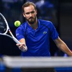 Petenis Daniil Medvedev memukul bola tenis dengan raket di lapangan indoor
