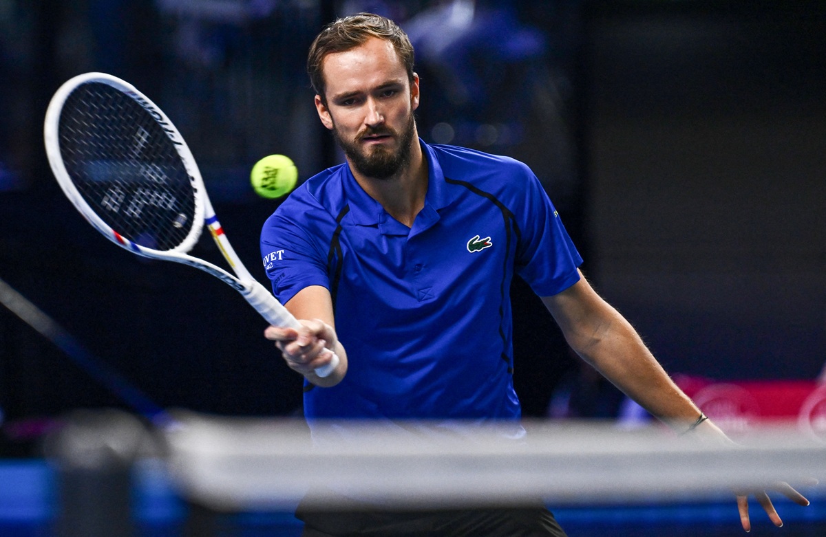 Petenis Daniil Medvedev memukul bola tenis dengan raket di lapangan indoor