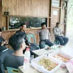 Sejumlah polisi dan warga duduk bersama sambil minum kopi di warung kayu sederhana