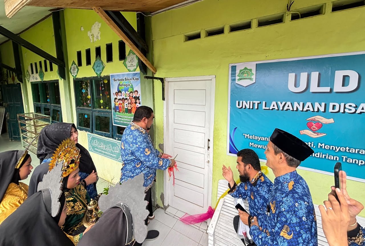 Peresmian ruang Unit Layanan Disabilitas di sebuah madrasah, ditandai pemotongan pita di depan pintu ruangan berplang ULD