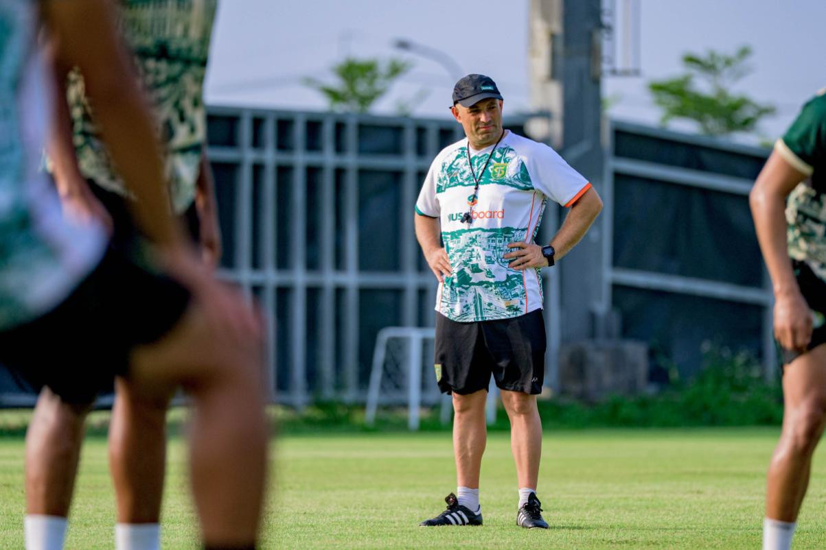 Pelatih Bernardo Tavares berdiri di lapangan latihan bersama pemain Persebaya