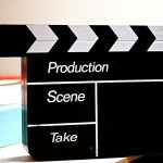 Papan clapperboard produksi film hitam putih di atas meja