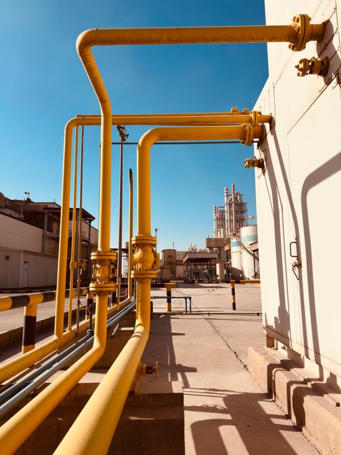 Pipa gas industri berwarna kuning dengan latar langit biru