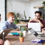 Sekelompok pekerja muda berkolaborasi di kantor modern dengan laptop