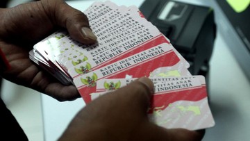 Tangan memegang sejumlah Kartu Identitas Anak berwarna merah putih