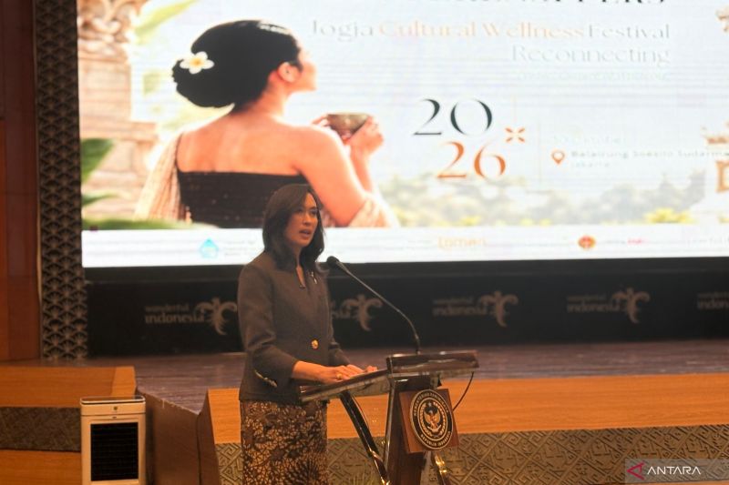 Menteri Pariwisata berbicara di podium konferensi pers dengan latar spanduk Jogja Cultural Wellness Festival 2026