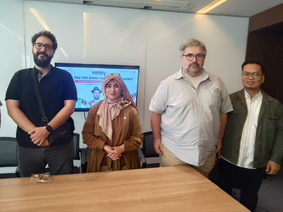 Foto bersama empat orang di depan layar bertuliskan SANFFEST, perempuan berhijab cokelat berdiri di tengah