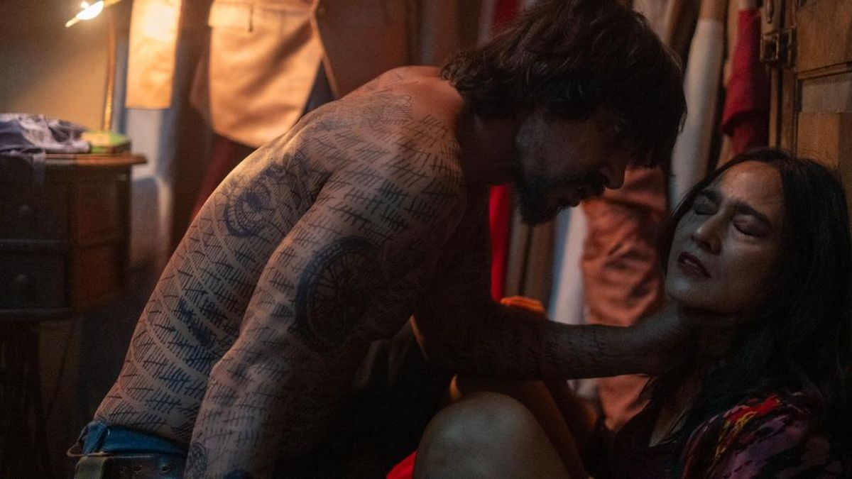 Adegan tegang film Secrets, pria bertato mencengkeram perempuan di ruangan remang
