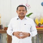 Seorang pejabat berbicara di depan kamera dengan latar deretan piala dan logo Bandung Digital Safety Forum 2026