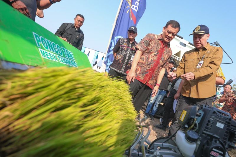 Sejumlah pejabat meninjau mesin tanam padi di lahan pertanian