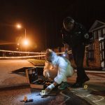 Petugas kepolisian dan penyidik memeriksa barang bukti di lokasi kejadian pada malam hari