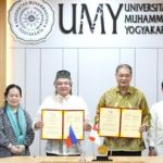 Para perwakilan UMY dan MSU-IIT memegang dokumen kerja sama di depan latar Universitas Muhammadiyah Yogyakarta